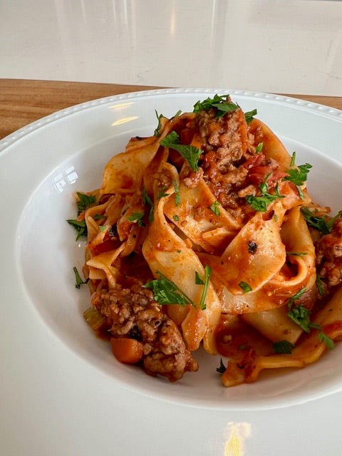 Bowl of plated Tandoori Glory Bolognese with Pappardelle