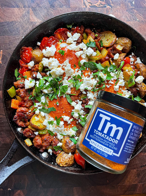 Skillet of Tomatador Breakfast Hash with jar of Spiceology Tomatador blend