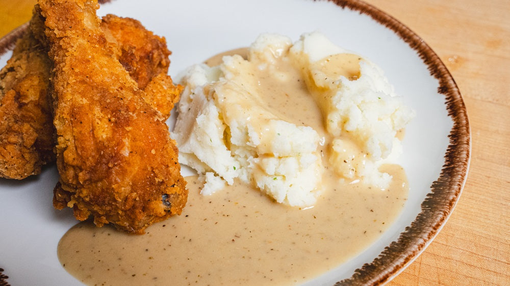 Plate with fried chicken and mashed potatoes topped with Greek Freak Brown Country Gravy