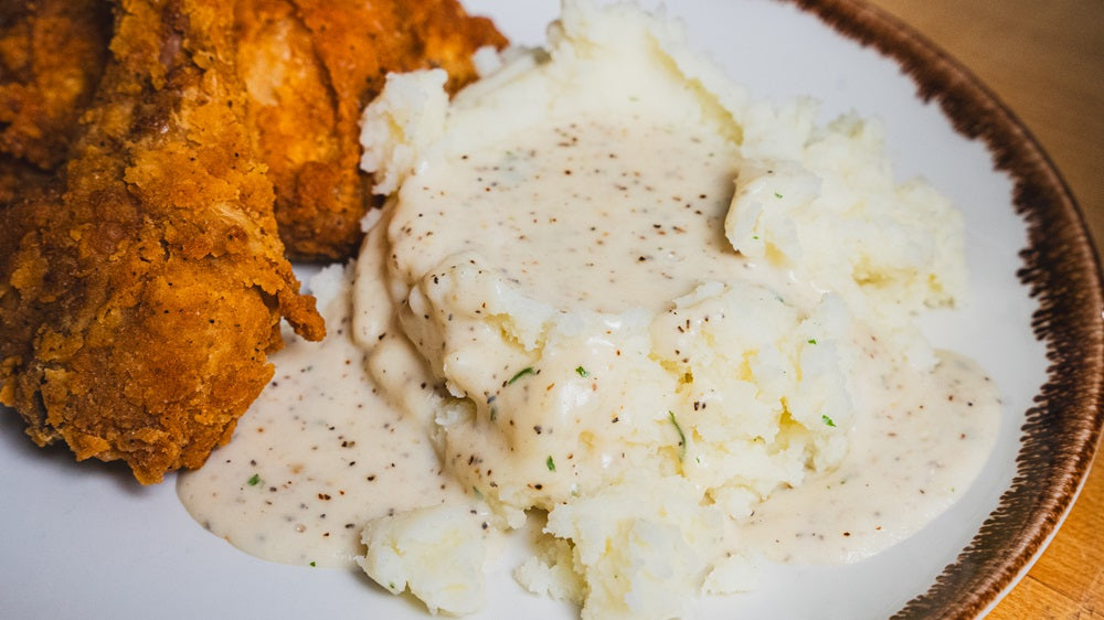 Plate with fried chicken and mashed potatoes topped with Vampire Killer White Country Gravy