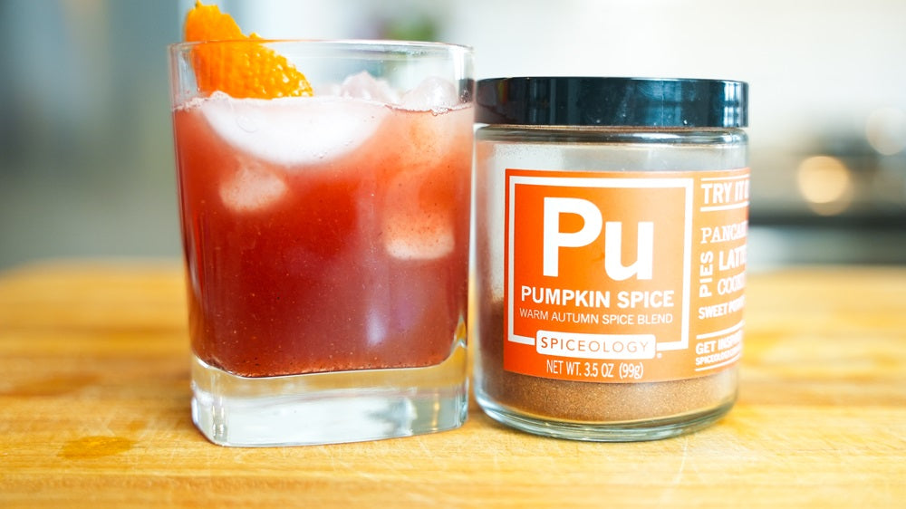 Glass with Pumpkin Spice Holiday Fizz Mocktail next to a Spiceology Pumpkin Spice jar