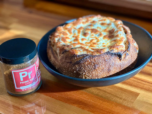 Plated French Mushroom Soup Bread Bowl Topped with Melted Cheese next to Spiceology Prime Rub blend jar