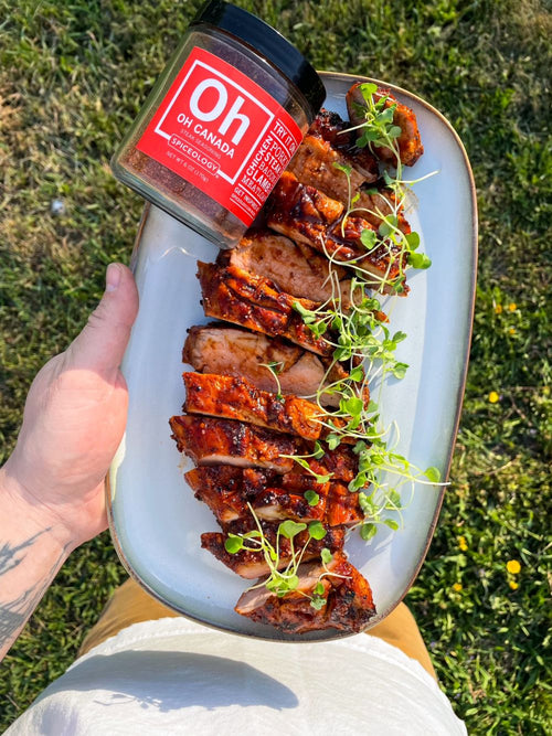Chef Ryan holding a plate of finished and sliced grilled pork tenderloin with a jar of Spiceology Oh Canada on the plate