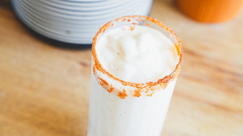 Glass filled with Frosted Peach Lemonade Milkshake and rimmed with Spiceology Smoky Honey Habanero seasoning