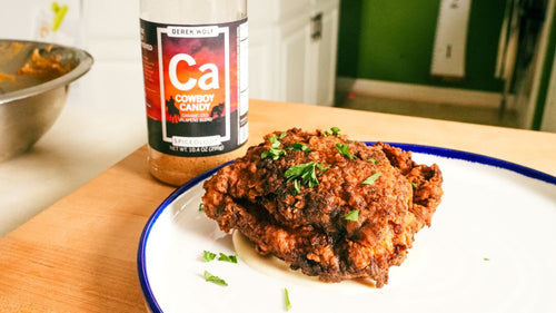 Plated and Finished Fried Chicken Thigh next to a jar of Spiceology Cowboy Candy seasoning