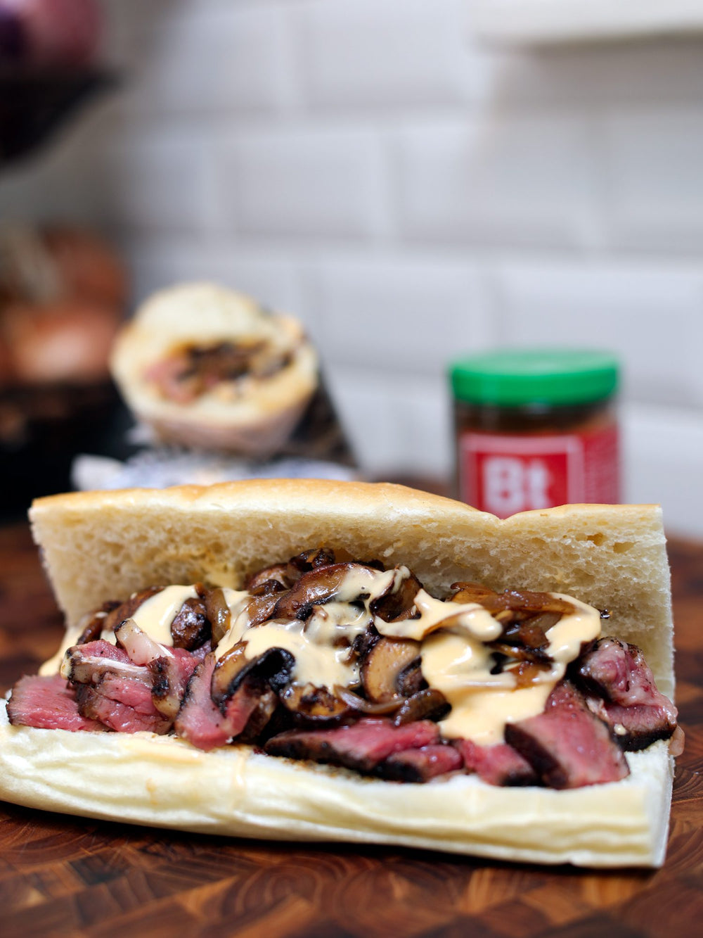 a philly cheesesteak on a cutting board