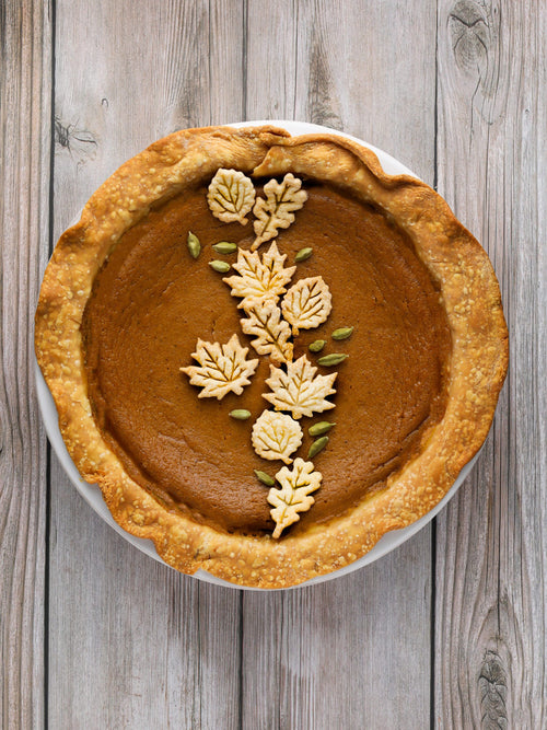 a pumpkin pie on a wood background