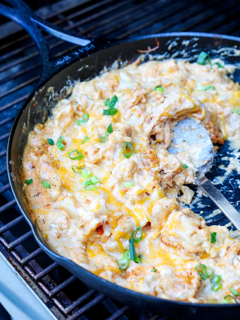 a skillet with mac & cheese on a grill