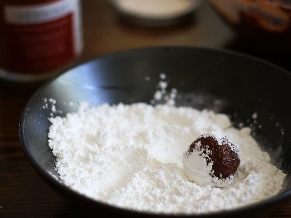 Spiced chocolate crinkle cookie balls rolled in powdered sugar