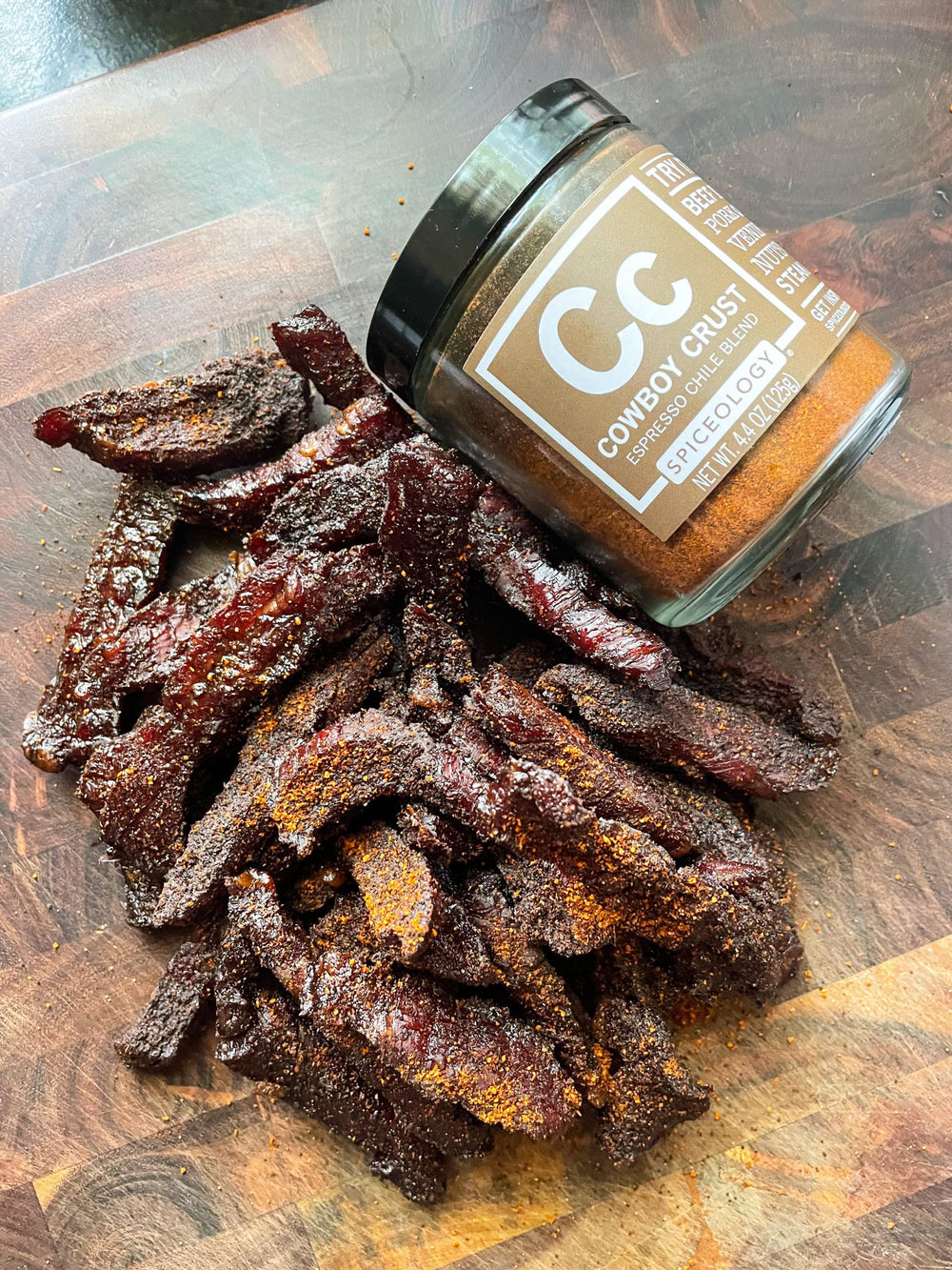 cowboy crust beef jerky pieces on cutting board with spice jar