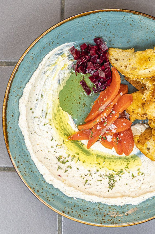 Labneh in a bowl with cured salmon and bagel chips