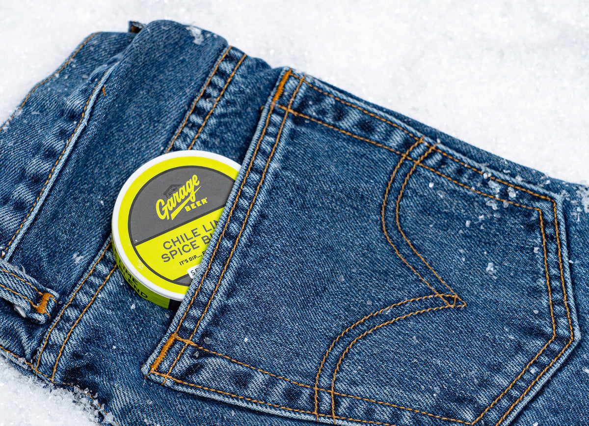 A Garage Beer Chile Lime Spice Dip tin tucked in the back pocket of a pair of jeans