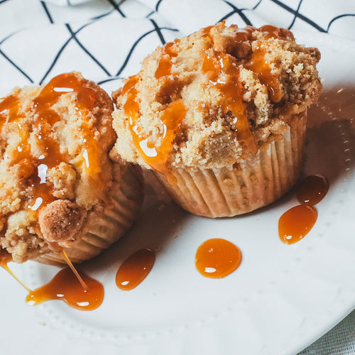 Overhead close-up of a caramel-drizzled muffin on a white ceramic plate