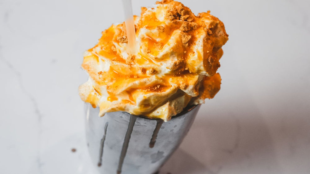 Swirled soft-serve ice cream presented in a metal cup with clean styling