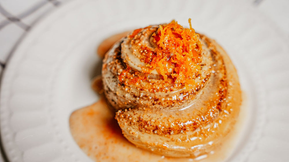 Smoky Honey Habanero Orange Cinnamon Rolls featuring a soft, bakery-style cinnamon rolls infused with bright orange zest and finished with Spiceology's Smoky Honey Habanero seasoning in a glaze that delivers layered sweet heat on a white plate
