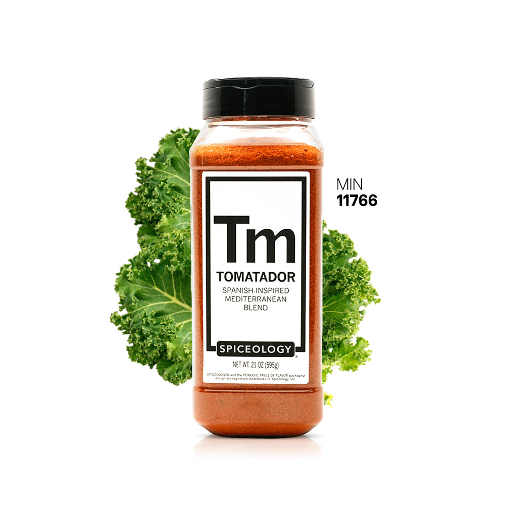 Spiceology Tomatador jar with green kale leaves on a white background
