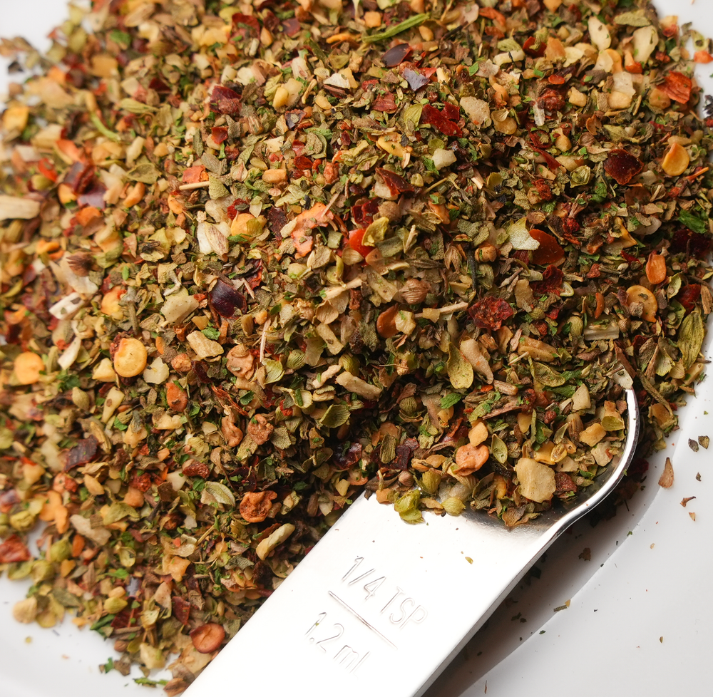 Herb blend with a spoon on a white background