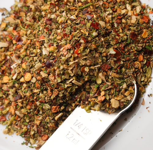 Herb blend with a spoon on a white background