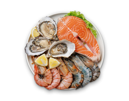 Seafood platter with salmon fillet, oysters, shrimp, and lemon slices on a white plate