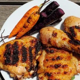 Dry brined chicken on plate with roasted carrots