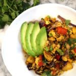 vegan breakfast scramble in a bowl topped with avocado