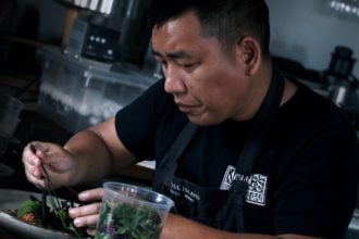 Chef Chong placing microgreens on the plate