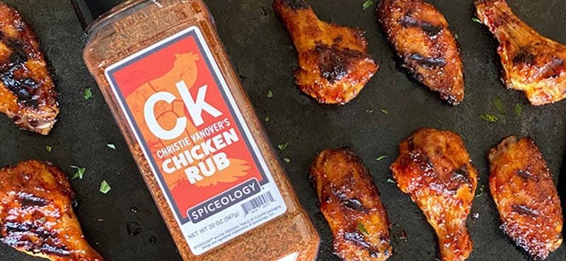 Christie Vanover's Chicken Rub next to a lineup of cooked chicken wings