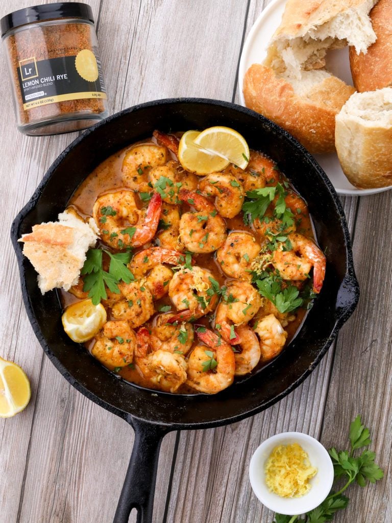 a skillet with cooked prawns on a wood background
