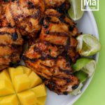 grilled mango tango chicken on plate with mango and limes