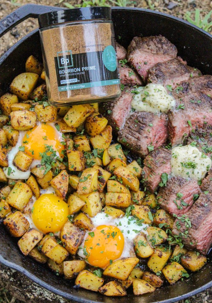 Bourbon prime steak and eggs in cast iron with spice jar