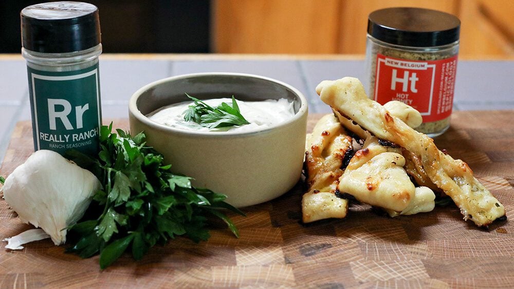 Hot honey pizza twists on cutting board with bowl of ranch dip