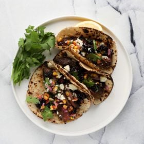 steak tacos with blackberry corn salsa on white background