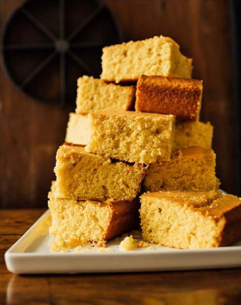 Isaac's cornbread cut and stacked on white plate
