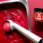 raspberry chipotle sorbet in metal container with ice cream scooper