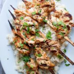 maui wowee grilled chicken skewers on top of bed of rice on white plate
